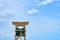 Wooden lifeguard tower against a blue sky.