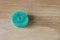 Wooden light background and one round light blue marmalade. Gelatinous sweet fruit candies for children. Sweets and pleasures