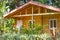 Wooden lodge for rest among tropical flowers and plants
