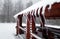 Wooden log pavillion in snow with icicles on roof