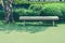 Wooden long bench stand on green grass meadow field of outdoor garden in Japanese style at public park.