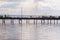 Wooden long bridge over a sea plait, river at sunset in perpektive, against a background of reeds, landscape