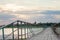 Wooden long bridge over a sea plait, river at sunset in perpektive, against a background of reeds, landscape