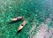 Wooden long-tail boats on emerald sea with coral reef