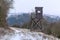 Wooden lookout tower for hunting in the woods and on meadow