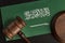 Wooden mallet justice on Saudi Arabia flag. Law library. Law and justice concept
