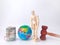 Wooden mannequin banknotes, earth globe and gavel on a white background