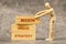 Wooden mannequin building up wooden blocks with STRATEGY, VISION and MISSION text