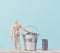 A wooden mannequin and coins in a miniature bucket on a blue background, a concept of high income, subsidy