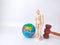 Wooden mannequin holding,earth globe and gavel on a white background