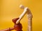 Wooden mannequin holding wooden gavel on a yellow background