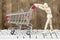 Wooden mannequin pushing empty shopping cart on computer keyboard