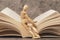 Wooden mannequin sitting on the open book