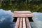 Wooden masonry for fishing, among green plants on a pond