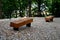 Wooden massive park bench shape block with metal legs on granite natural cobblestone irregular brown gray pavement on pedestrian