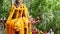 Wooden miniature guardian spirit house. Small buddhist temple shrine, colorful flower garlands. San phra phum erected to bring