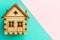 Wooden model house on a Geometric pink and turquoise pastel background with copy space. Pattern, form. Wooden house handmade.