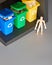 Wooden model of human and three color coded recycle bins, isometric projection with copy-space. Recycling sign on the bins, blue,