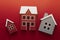 Wooden models of houses. Rent, buying or mortgage concept. Red background