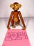 A wooden monkey toy with a sticky note with 2024.