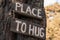 A wooden motivating tablet on an old pine tree in an autumn park says â€œPlace to hug