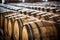 Wooden oak port barrels in neat rows. Wine barrels in a old dark wine cellar. Generative AI