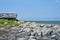 Wooden observatory platform on Island cape on a sunny day. Rocks rounded by the ocean.