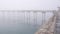 Wooden Ocean Beach pier in fog, misty calm boardwalk in haze, California coast.