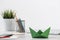 Wooden office desk with green origami boat.