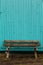 Wooden old, aged and weathered bench outside on a turquoise colored background