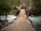 Wooden old bridge in forest over wild river stock images