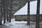 Wooden old house with snow on the roof with small window in the forest in winter