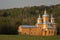 Wooden Orthodox church on the background of a hill covered with forests. On the sunset