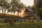 Wooden outdoor playground slide in rural garden park, children sunset