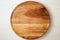 A Wooden Oval Shaped Cutting Board On A White Wall