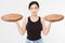 Wooden pan. Young asian woman in summer tshirt holding empty pizza tray isolated on white background. Copy space and mock up.