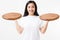 Wooden pan. Young asian woman in summer tshirt holding empty pizza tray isolated on white background. Copy space and mock up.