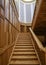 Wooden panels on the walls and a wooden staircase in the interior of a spacious building