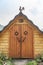 Wooden pantry with doors and roof ridge decorated with a figure of a rooster