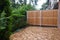 Wooden partition and wooden tiles,on the, with ivy and Thuja plants covered, terrace of a residential building