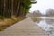 Wooden path along the shore of the lake, plank deck, modern landscape design, recreation area by the water