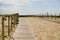 Wooden path coast access with sand beach waves entrance to ocean atlantic sea