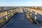 Wooden path with fence to the beach. Walkway on seashore in the morning. Atlantic Ocean coast in Portugal.