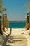 Wooden path guiding to a sandy beach. Sunny summer day on the beach. hot days. Palm trees. Exotic destination