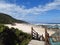 Wooden path leading to secluded beach with rocks and coastal bush