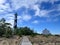 A wooden path leads between a house and the black and white diamond-shaped Cape Lookout lighthouse on the Outer Banks of North