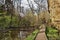 Wooden path at spring Peklo valley with Robecsky potok creek and big rock in Machuv kraj tourist area