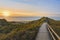 Wooden path and stairs crossing the dunes to the beach of Norddorf, Amrum, in sunset