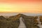 Wooden path and stairs crossing the dunes to the beach of Norddorf, Amrum, in sunset