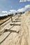 Wooden path stairs on sand up to blue sky